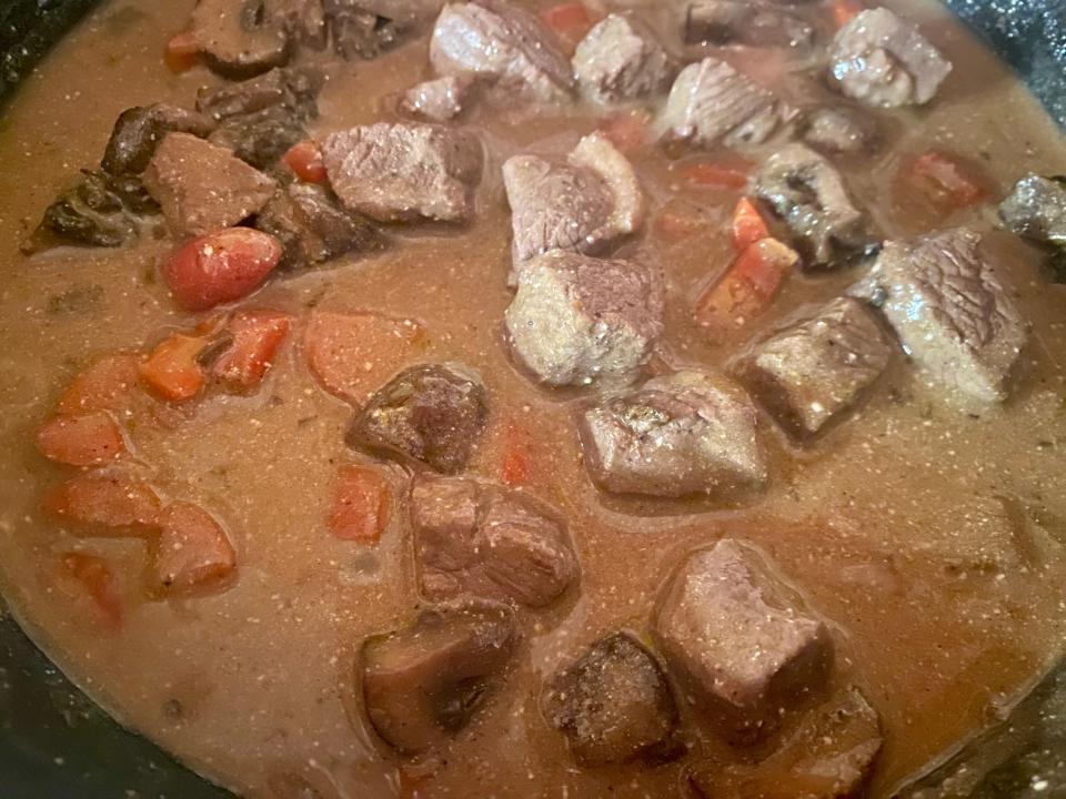 Beef, sauce, and vegetables in a pan.