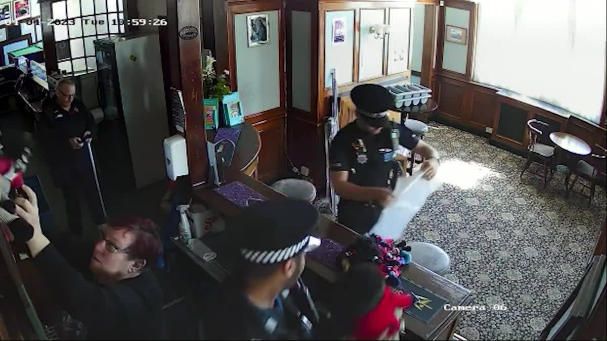 Officers enter the pub to remove the dolls (Benice Ryley / SWNS)