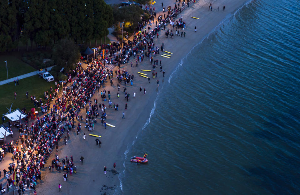 Participants of the Dark Mofo Nude Solstice Swim are seen gathered at the River Derwent at dawn, in Hobart, on June  22, 2018. (AAP Image/Rob Blakers) 