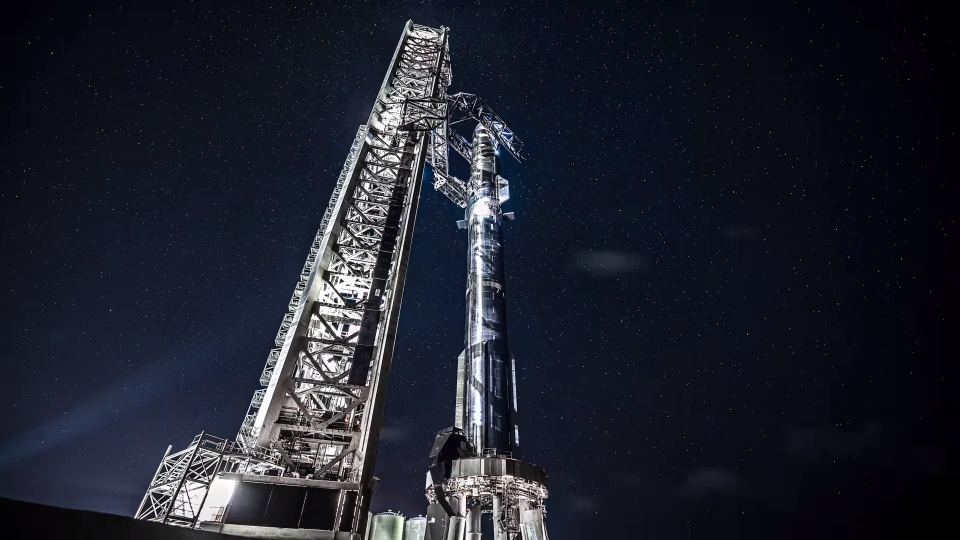 A silver SpaceX Starship atop its booster on the launch pad at Starbase in South Texas