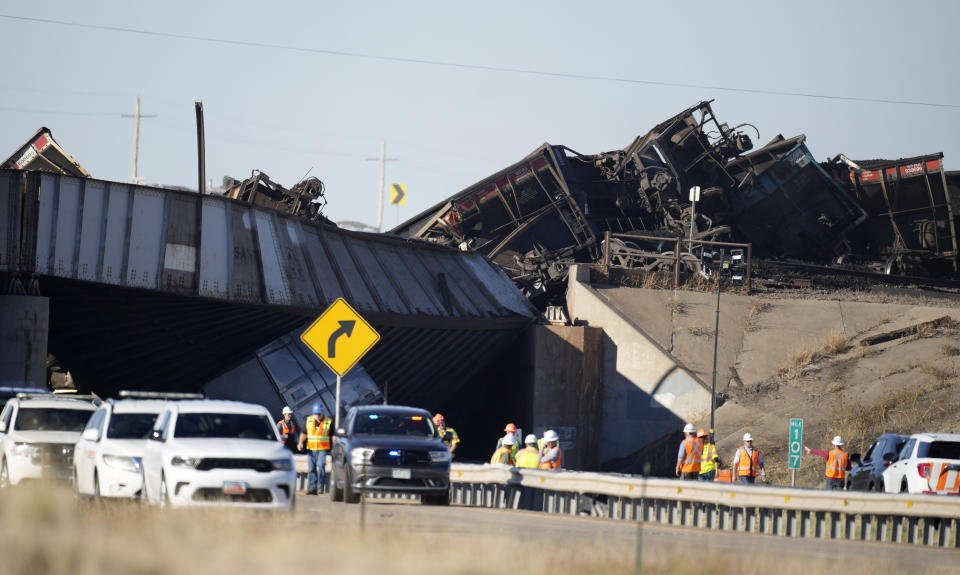 Workers toil to clear cars that derailed in an accident over Interstate 25 northbound, Monday, Oct. 16, 2023, north of Pueblo, Colo. (AP Photo/David Zalubowski)