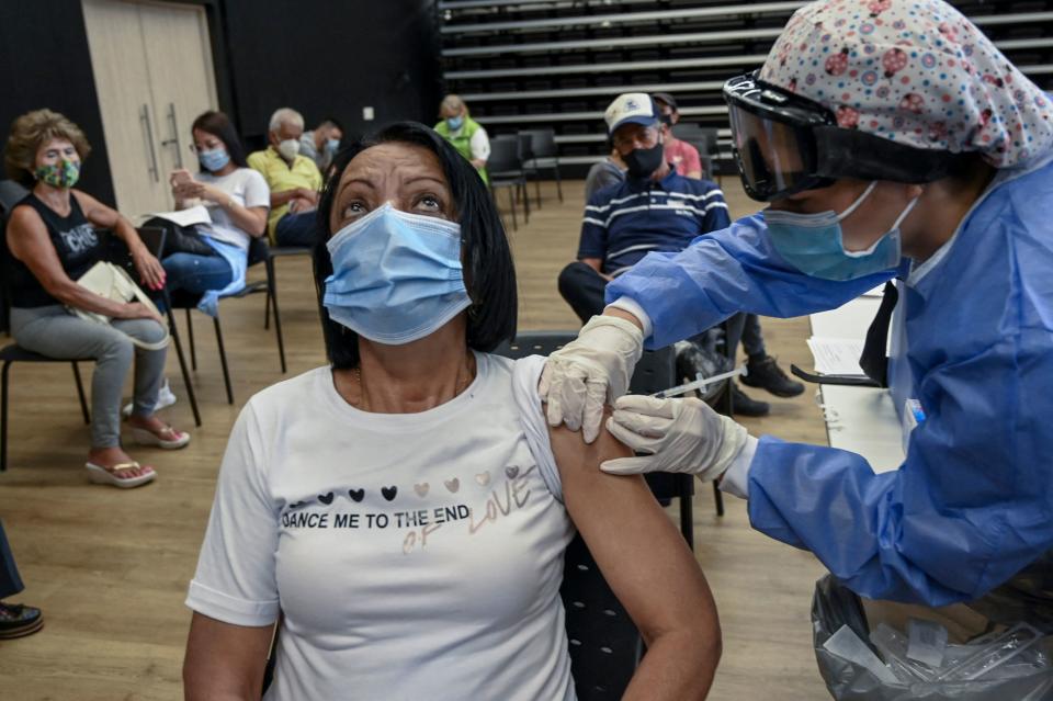 Una mujer es inoculada con la vacuna Oxford / AstraZeneca contra COVID-19 en un centro de vacunación, en medio de la pandemia del nuevo coronavirus, en Medellín, Colombia, el 7 de abril de 2021. (Foto de JOAQUIN SARMIENTO / AFP a través de Getty Images)