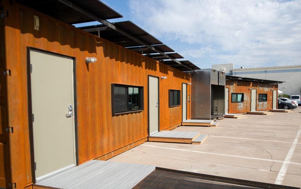 Shelters made out of shipping containers stand in the parking lot of the St. Vincent de Paul shelter in Phoenix on July 27, 2023.