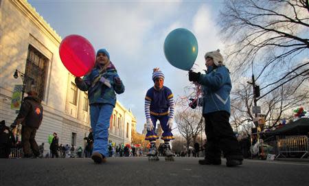 A clown hands out balloons before the start of the 87th Macy's Thanksgiving Day Parade in New York November 28, 2013. REUTERS/Gary Hershorn