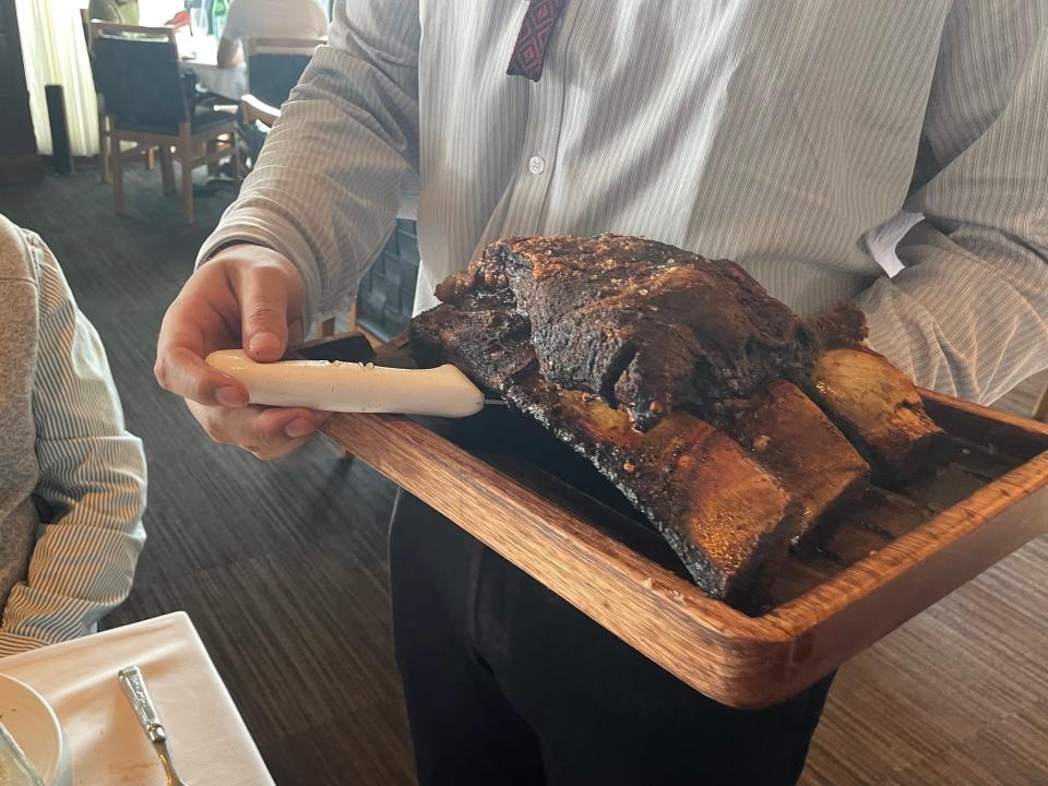 plater of short ribs on a wooden serving tray at fogo do chao steakhouse