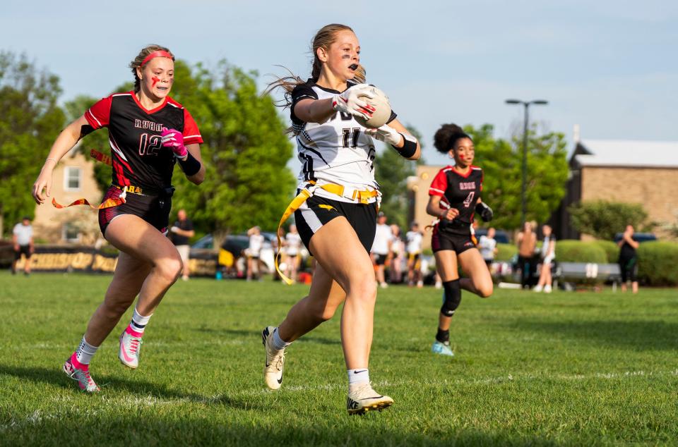 Archbishop Wood's Lauren Greer (11) scores a touchdown against Archbishop Ryan's Kennedie Lapacinski (12) during a girls' flag football semifinal game in Warminster on Wednesday, May 8, 2024.