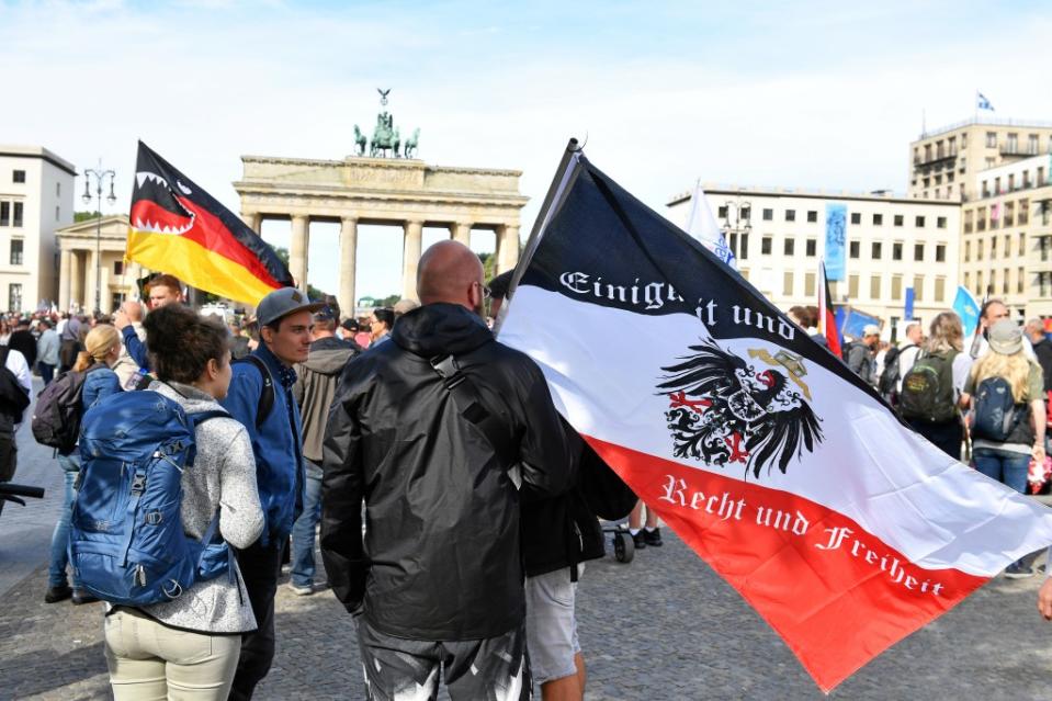 29.08.2020, Berlin: Ein Teilnehmer hält vor einer Demonstration gegen die Corona-Maßnahmen eine Reichsflagge vor dem Brandenburger Tor. Foto: Bernd Von Jutrczenka/dpa +++ dpa-Bildfunk +++<span class="copyright">Bernd von Jutrczenka / dpa</span>