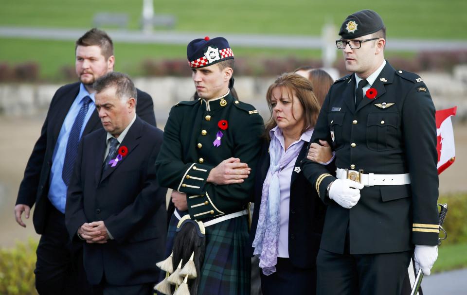 Soldiers escort Kathy Cirillo (2nd R) during the funeral procession for her son Cpl. Nathan Cirillo in Hamilton, Ontario October 28, 2014. Corporal Nathan Cirillo, 24, was one of two soldiers killed in a pair of attacks police said were carried out independently by radical recent converts to Islam at a time when Canada's military is stepping up its involvement in air strikes against Islamic State militants in the Middle East. REUTERS/Mark Blinch (CANADA - Tags: POLITICS MILITARY CRIME LAW OBITUARY)