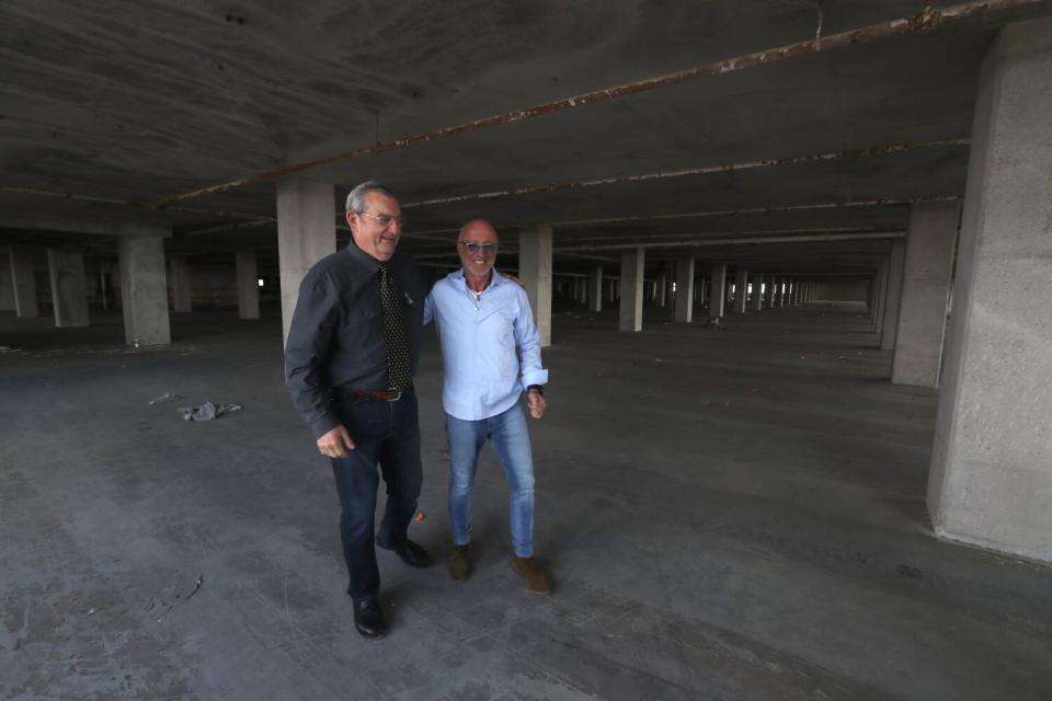 Two men walk through a building.