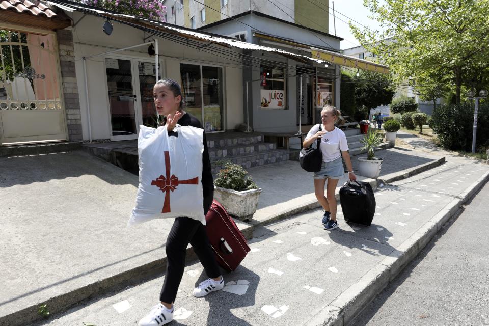 Students leave a campus which will be accommodate Afghans, in Tirana, Albania, Wednesday, Aug. 18, 2021. Albania are preparing for the arrival of Afghans who worked with Western peacekeeping forces in Afghanistan and are now threatened by the Taliban. (AP Photo/Franc Zhurda)