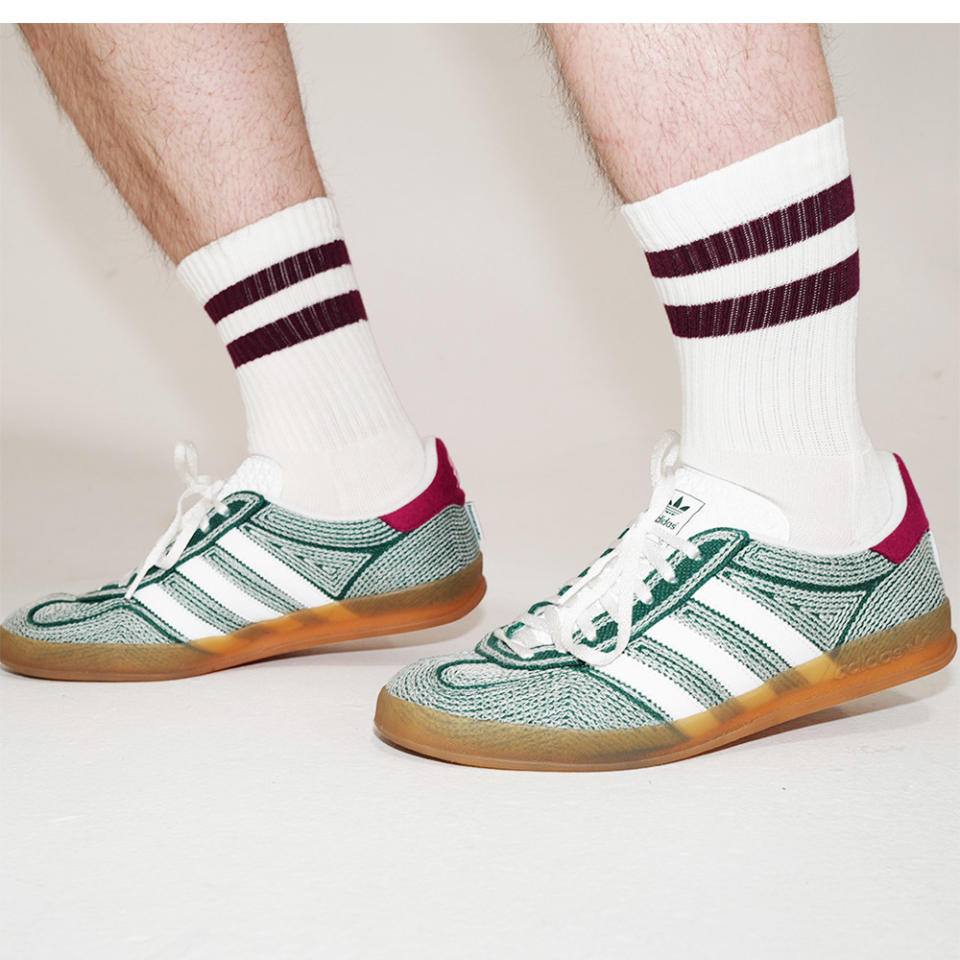 Footwear News Shop editor Adam Mansuroglu wears Bombas red striped socks with green sneakers 
