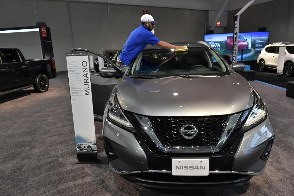 A worker readies a Nissan for exhibit at the 2020 New England Auto Show Press Preview 