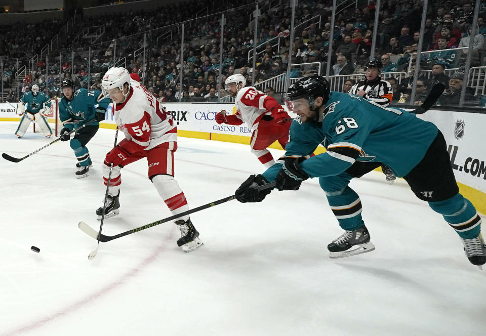 Detroit Red Wings left wing Matt Puempel (54) moves the puck past San Jose Sharks center Melker Karlsson (68) during the second period of an NHL hockey game Monday, March 25, 2019, in San Jose, Calif. (AP Photo/Tony Avelar)