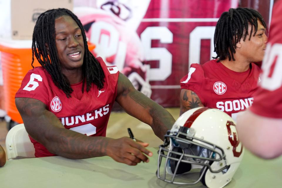 Oklahoma Sooners wide receiver Deion Burks signs a helmet for a fan during Meet the Sooners Day for the University of Oklahoma football team at Gaylord Family-Oklahoma Memorial stadium in Norman, Okla. Saturday, Aug. 3, 2024.