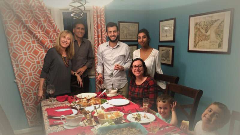 A family and their au pair around a Thanksgiving table
