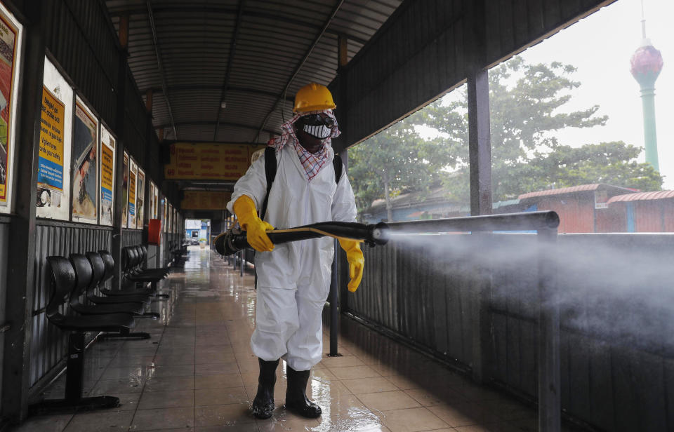 A Sri Lankan worker sprays disinfectants at a bus terminal to prevent the spread of coronavirus in Colombo, Sri Lanka, Monday, Oct. 26, 2020. To contain the spread, the government has closed schools and banned gatherings across Sri Lanka, and a curfew is in effect in many parts of Western province, where the infections have been concentrated. (AP Photo/Eranga Jayawardena)