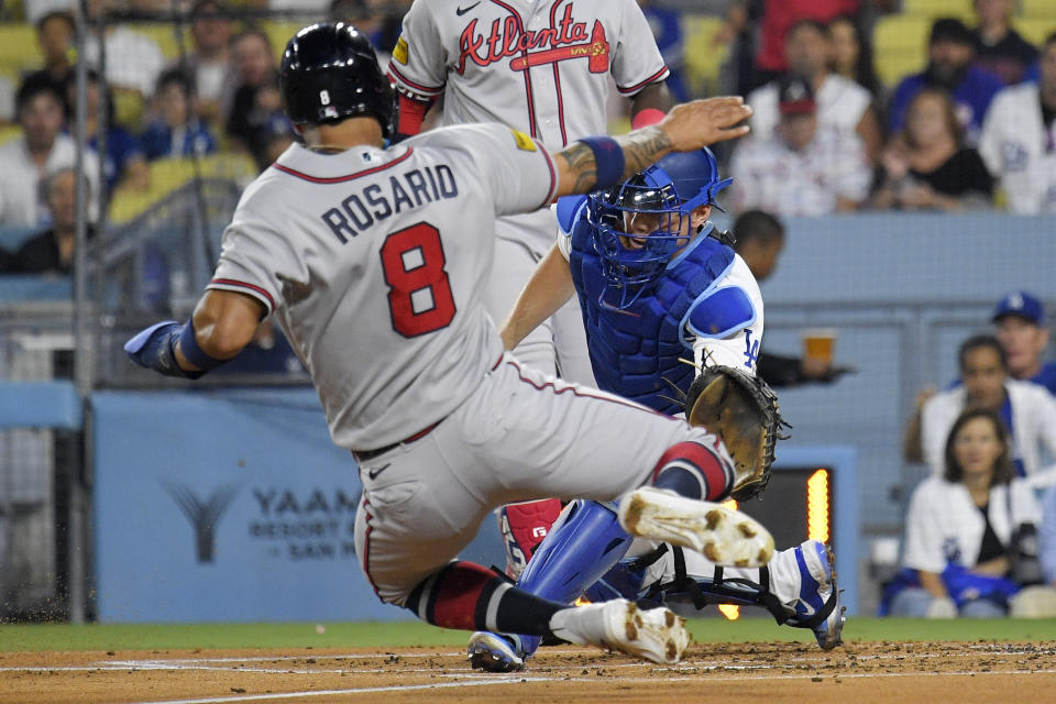 Atlanta Braves' Eddie Rosario, left, attempts to steal home before being tagged out by Los Angeles Dodgers catcher Will Smith during the second inning of a baseball game Friday, Sept. 1, 2023, in Los Angeles. (AP Photo/Mark J. Terrill)