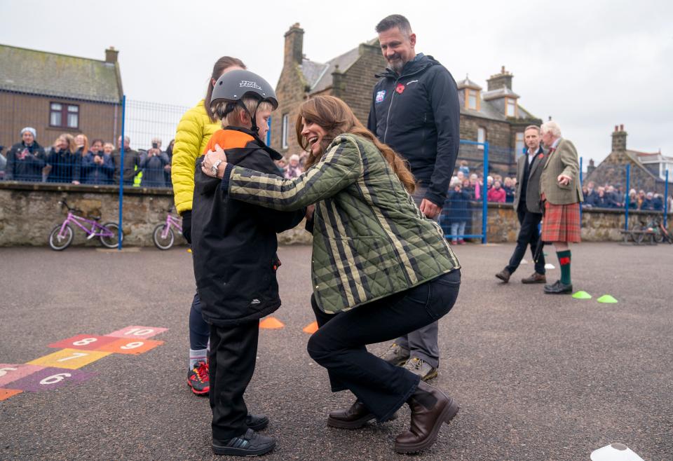 Catherine, Princess of Wales, comforts a Burghead Primary School student who fell off his bike while taking part in Outfit Moray, an award-winning charity delivering life-changing outdoor learning and adventure activity programs to young people on Nov. 2, 2023, in Moray, Scotland.