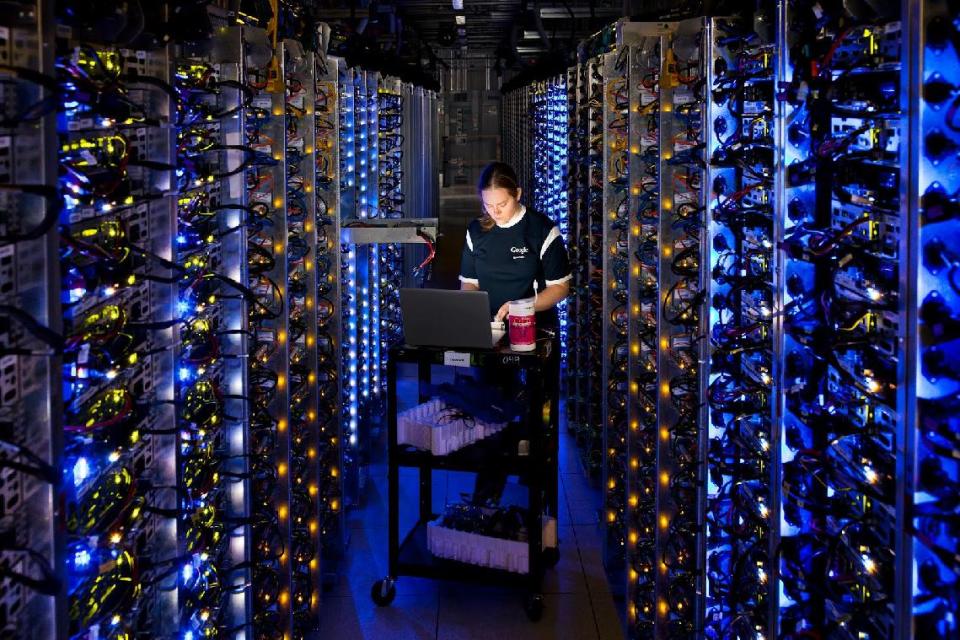 This undated photo provided by Google shows a Google technician working on some of the computers in the Dalles, Ore., data center. Google is opening a virtual window into the secretive data centers that serve as its nerve center. The unprecedented peek is being provided through a new website unveiled Wednesday, Oct. 17, 2012. The site features photos from inside some of the eight data centers that Google Inc. already has running in the U.S., Finland and Belgium. (AP Photo/Google, Connie Zhou)