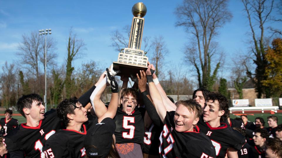 Members of the Haddonfield Memorial High School football team hoist the Mayor's Trophy after Haddonfield defeated Haddon Heights, 45-18, in the Thanksgiving Day football game played in Haddonfield on Thursday, November 24, 2022.  