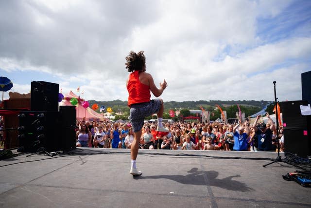 Joe Wicks jumps up and down on stage in front of crowds of people 