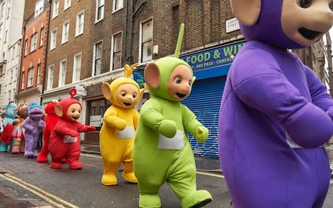 Performers dressed as children's toys and characters from television shows, including the Teletubbies, prepare to participate in the Hamleys Christmas Toy Parade on Regent Street in London - Credit: AFP