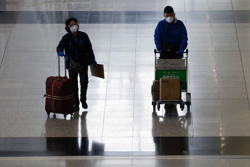 Passengers with protective masks arrive at Hong Kong International Airport, following the novel coronavirus disease (COVID-19) outbreak, in Hong Kong