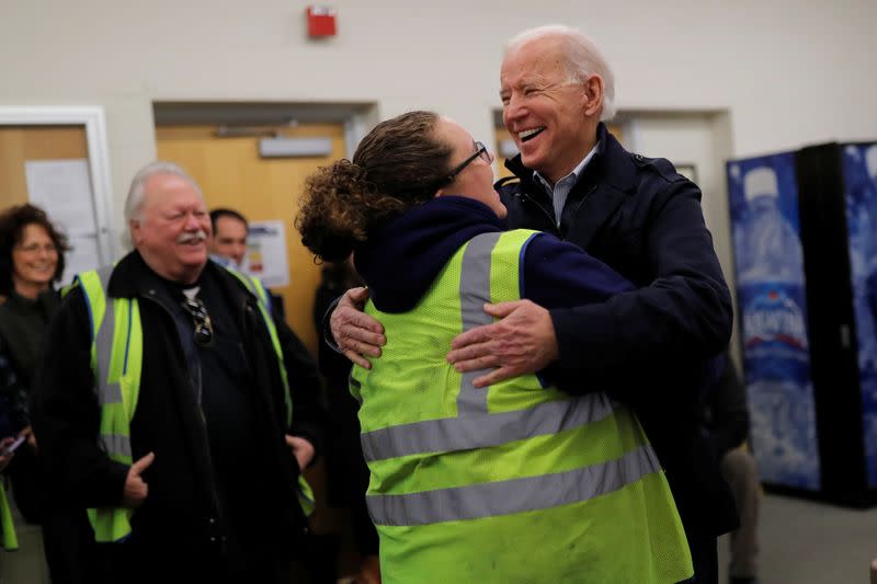 Democratic 2020 U.S. presidential candidate and former Vice President Joe Biden hugs a school bus driver during a visit at a bus garage while campaigning in Nashua, New Hampshire U.S.