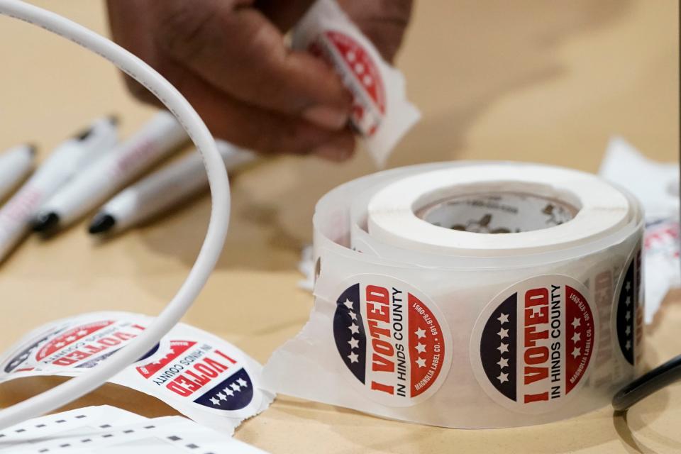 A Jackson, Miss., precinct worker reaches for more "I Voted" stickers, Tuesday, Nov. 7, 2023. All voters are given a sticker when they receive their paper ballot.