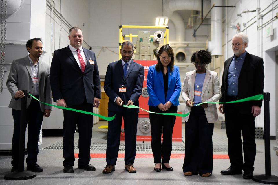 Muhsin Ameen, from left, of Argonne National Lab, Jim Gamble, of Wabtec, Siddiq Khan, of the U.S. Dept. of Energy, Xin Sun, of ORNL, Melissa Shurland, of USDOT/Federal Railroad Administration, and Dean Edwards, of ORNL, cut the ribbon unveiling the single cylinder, dual-fuel locomotive engine powered by hydrogen at Oak Ridge National Laboratory's National Transportation Research Center in Hardin Valley, last Wednesday. The engine, being developed by ORNL, Argonne National Laboratory and Wabtec Corporation, is designed to help decarbonize the rail industry throughout North America.
(Photo: Calvin Mattheis/For The Oak Ridger)