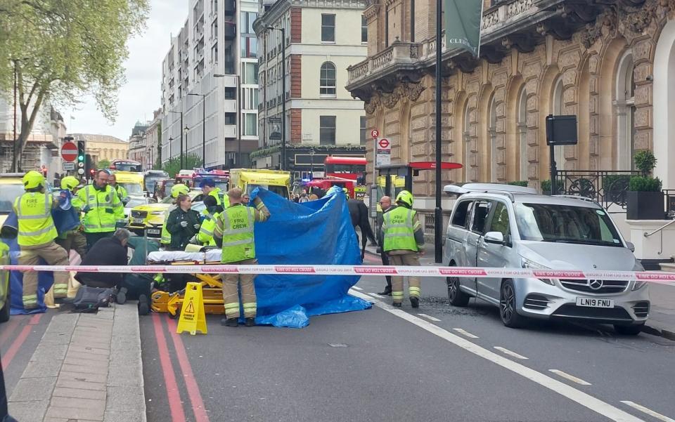 A cordon is set up to help the rider who was thrown off his horse outside the Clermont Hotel