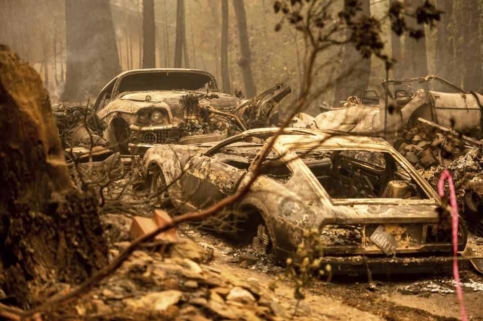 Following the Dixie Fire, scorched vehicles rest in a driveway in the Indian Falls community of Plumas County, Calif., on Monday, July 26, 2021. (AP Photo/Noah Berger)