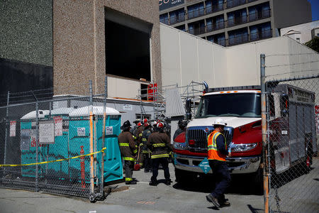 Firefighters and Pacific Gas and Electric (PG&E) workers gather outside substation after a fire broke out in San Francisco, California, U.S., April 21, 2017. REUTERS/Stephen Lam