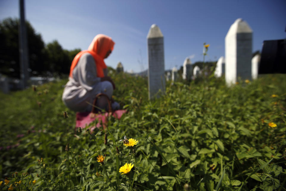 A Bosnian Muslim woman Sehida Abdurahtanovic gestures as she kneels by a grave at the memorial centre of Potocari near Srebrenica, 150 kms north east of Sarajevo, Bosnia, Tuesday, Aug. 14, 2018. The leader of Bosnia's Serbs has downplayed the massacre of some 8,000 Bosnian Muslims in Srebrenica during the war in 1995 and called for the reopening of an investigation into the worst carnage in Europe since World War II. (AP Photo/Darko Vojinovic)