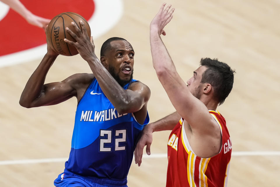 Khris Middleton with the ball in both hands up near his head looking for a shot over Danilo Gallinari who is defending with his arm outstretched.