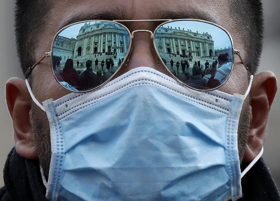 A man wears a face mask in St. Peter's Square at the Vatican during Pope Francis' weekly general audience, Wednesday, Feb. 26, 2020. (AP Photo/Alessandra Tarantino)