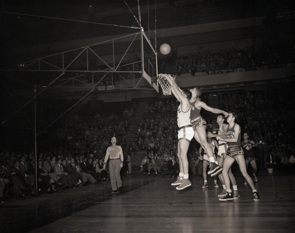 (Original Caption) 11/21/1950-New York, NY- Height is not important in basketball, but it helps a great deal if a player is good as well as tall, as evidenced by these two pro cagers leaping for the ball during a hectic moment on the court at Madison Square Garden. Photo shows Vince Boryla, #12 of the Knickerbockers and Chuck Cooper, #11 of Boston. Both men play forward positions on their perspective teams. Knicks lost 89 to 83.