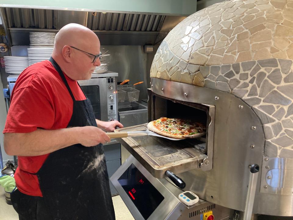 Dave Penzo, owner of Penzo Pizza Co., takes a pizza out of the oven at the Montepelier restaurant March 8, 2023.
