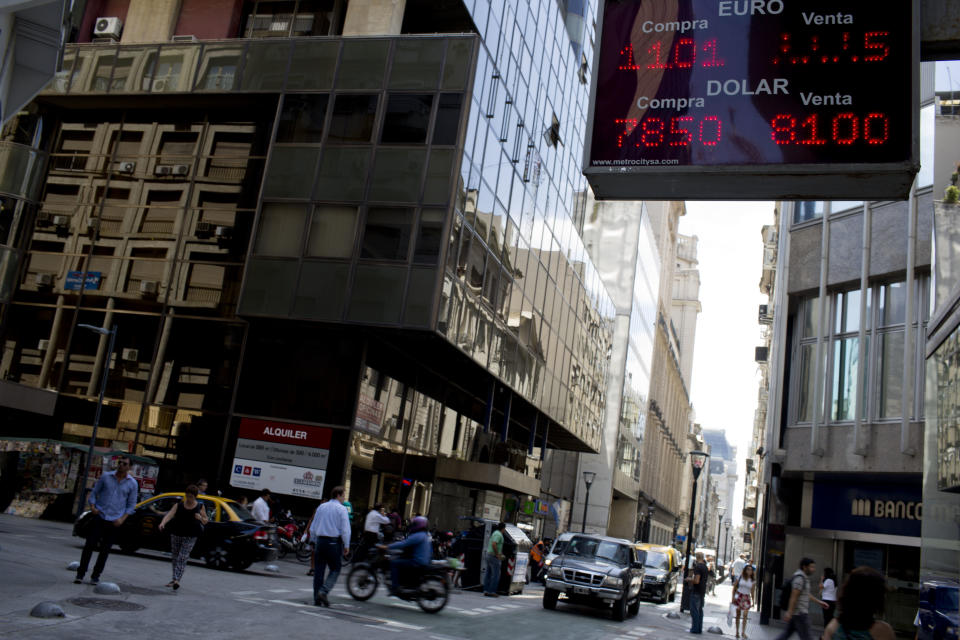 The goin rate of U.S. dollars and euros is displayed outside a foreign exchange business in Buenos Aires, Argentina, Monday, Jan. 27, 2014. The Argentine government announced Friday Jan. 24, it was relaxing restrictions on the purchase of U.S. dollars. The measure would start taking effect Monday, allowing Argentines to buy dollars for personal savings, reversing a 2012 restriction. (AP Photo/Natacha Pisarenko)