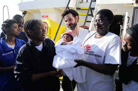 A woman (L), who just gave birth on board the Aquarius, reacts as she takes her newborn baby son, called Miracle, on board the ship, in the central Mediterranean Sea, May 26, 2018. Picture taken May 26, 2018. REUTERS/Guglielmo Mangiapane