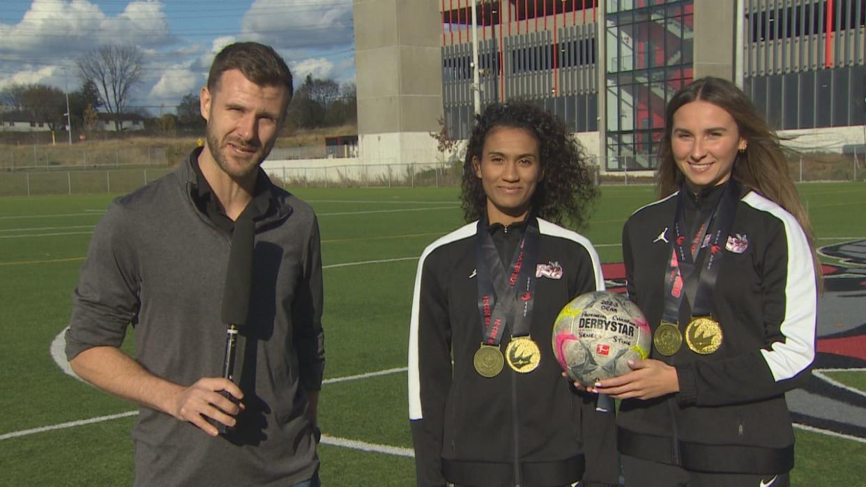 Seneca Sting co-captains Jordan Burke, left, and Carley Uddenberg, right, are pictured here after the team's big win in Summerside, P.E.I. on the weekend. Seneca won the Canadian Collegiate Athletic Association national championship in women's soccer. (CBC - image credit)