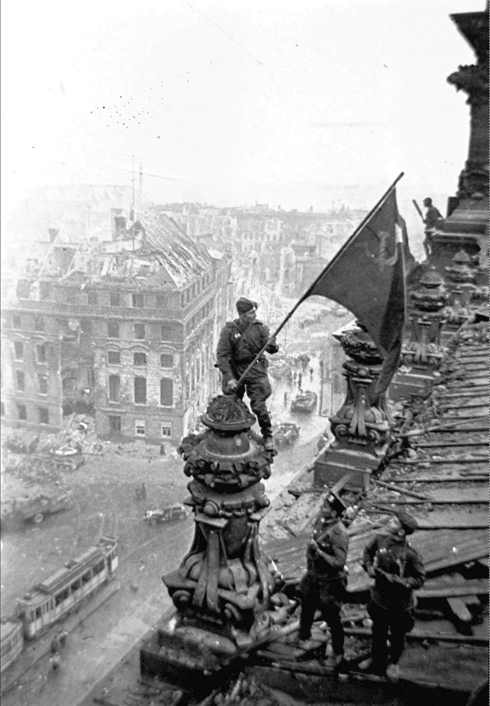 FILE - Soviet soldiers hoist the red flag over the Reichstag in Berlin, Germany in May 1945. The photo was made by Yevgeny Khaldei, a veteran photographer whose pictures of Soviet soldiers hoisting the red flag over the Reichstag in Berlin are among the best-known images of World War II. The Red Army doggedly pushed back the Nazis and slowly advanced until reaching Berlin, ending the war's European theater. (Yevgeny Khaldei, ITAR-TASS via AP, File)