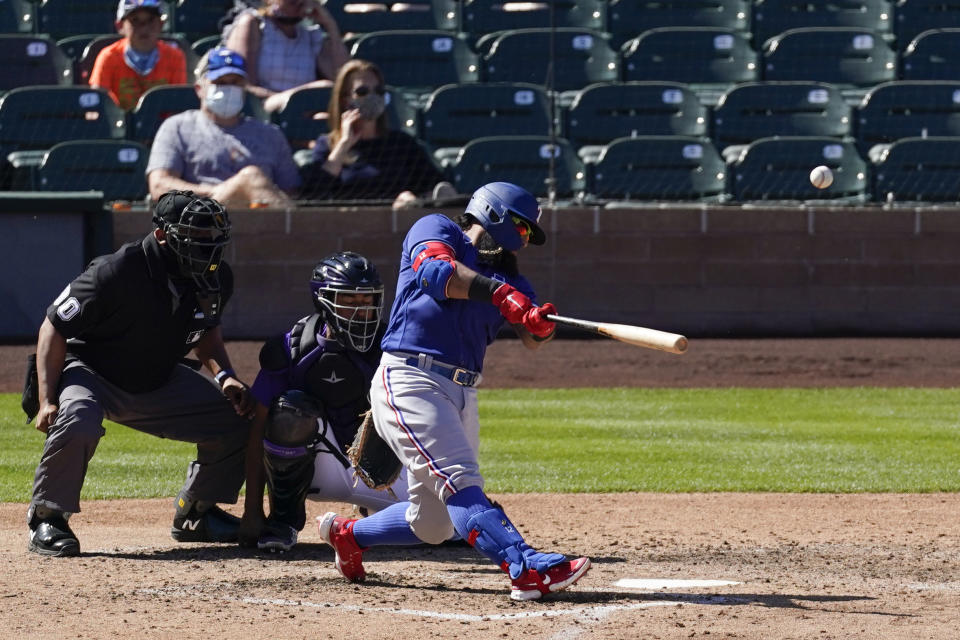 Texas Rangers' Rougned Odor (12) hits a home run during the sixth inning of a spring training baseball game against the Colorado Rockies Monday, March 22, 2021, in Scottsdale, Ariz. (AP Photo/Ashley Landis)