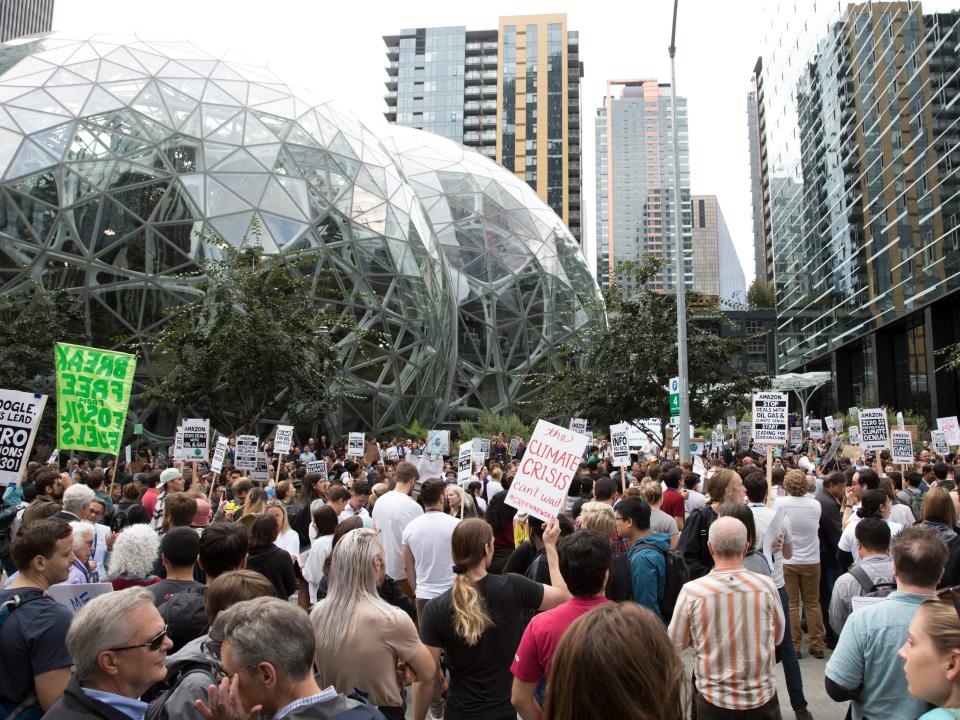 A large group of protesters with signs gather outside of Amazon's headquarters in Seattle.