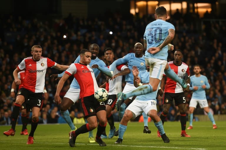 Feyenoord's midfielder Sofyan Amrabat (L) takes the ball on his knee after it clears Manchester City's defender Nicolas Otamendi (R) during the UEFA Champions League Group F football match November 21, 2017