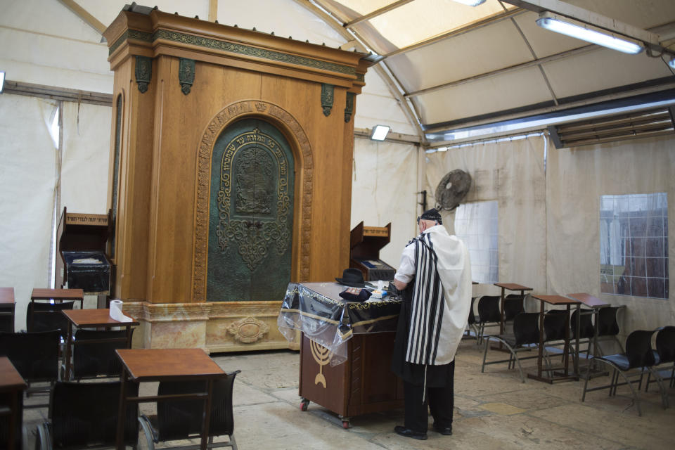 In this Wednesday, March 6, 2019 photo, a man prays in Hebron's holiest site, known to Jews as the Tomb of the Patriarchs and to Muslims as the Ibrahimi Mosque in the Israeli controlled part of the West Bank city of Hebron. The Falic family, owners of the ubiquitous chain of Duty Free America shops, fund a generous, and sometimes controversial, philanthropic empire in Israel that stretches deep into the West Bank. The family supports many mainstream causes as well as far right causes considered extreme even in Israel. (AP Photo/Ariel Schalit)