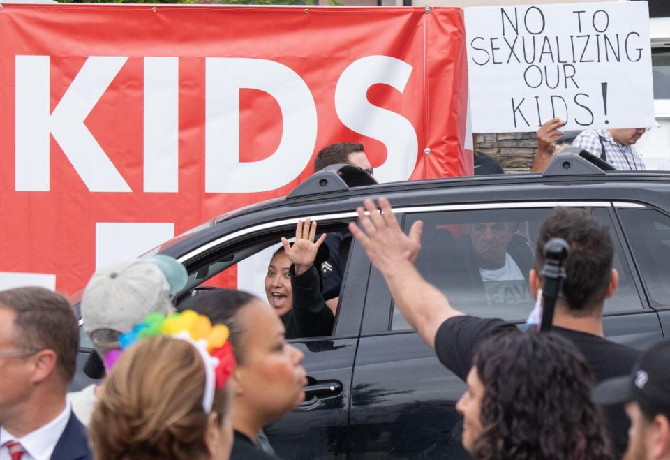 A motorist waves to show support for counterprotesters