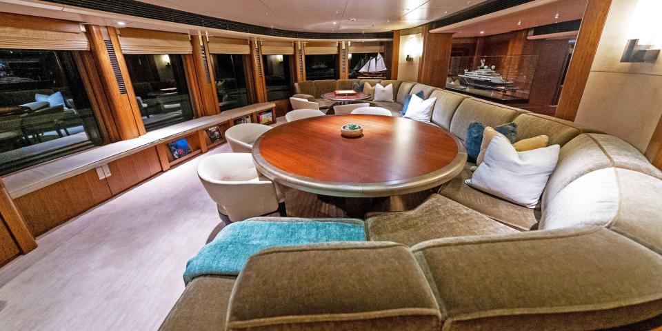 The dining room with couches and round seats surrounding two dining tables.