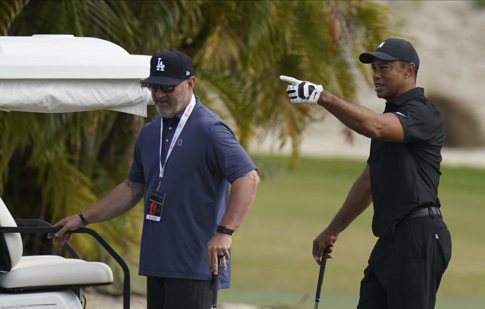 Tiger Woods, right, speaks with his trainer Kolby Wayne during a practice session at the Albany Golf Club, on the sidelines of day three of the Hero World Challenge Golf tour, in New Providence, Bahamas, Saturday, Dec. 4, 2021. (AP Photo/Fernando Llano)