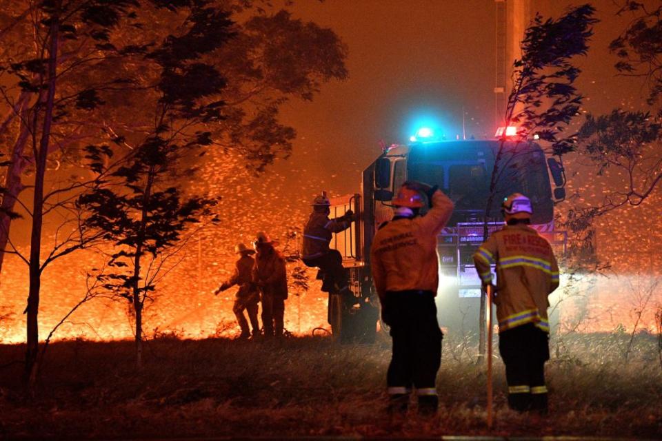 Firefighters hose down trees as they battle against bushfires around the town of Nowra on December 31, 2019. Source: Getty
